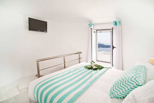 Ein Zimmer mit einem Bett, einer Fenster mit Meerblick und einer Wand-montierten Fernseher.