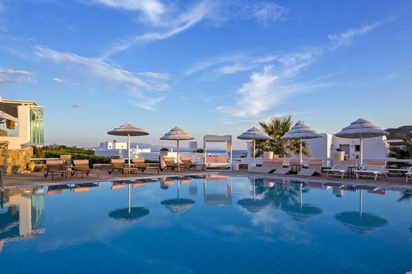 Archipelagos Hotel mit Pool und Lounge-Bereich im Freien mit Sonnenschirmen und Liegen.