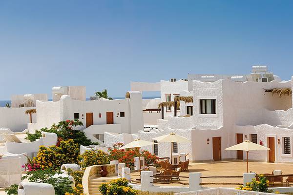 Außenbereich des Sharm Club Beach Resorts mit weißen Gebäuden und Palmen