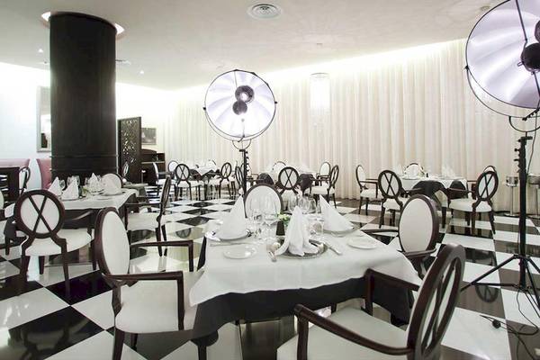Restaurant des Barcelo Bavaro Palace mit schwarzem und weißem Schachbrettboden und weißen Tischen.