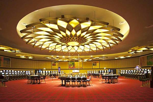 Casino im Barcelo Bavaro Palace mit großen Tischen und Spielautomaten.