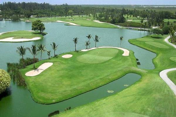 Luftaufnahme eines Golfplatzes mit Wasserhindernissen und Palmen