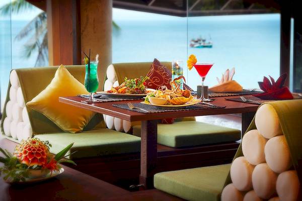 Essen und Getränke auf einem Tisch im Nora Buri Resort & Spa mit Blick auf das Meer