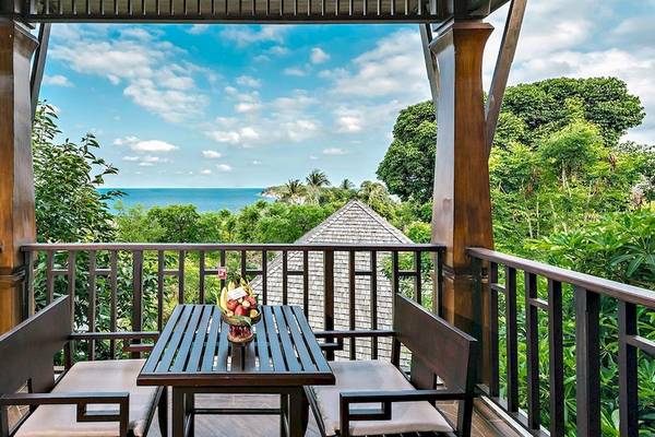 Aussicht von Balkon des Nora Buri Resort & Spa mit Meer, Himmel und Bäumen.