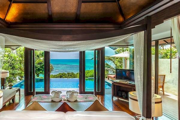 Schlafzimmer im Nora Buri Resort & Spa mit Meerblick, Himmelbett, Fernseher und Pool