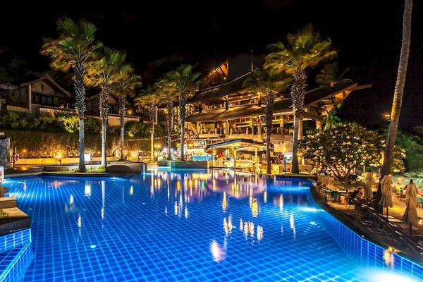 Nachtansicht des beleuchteten Swimmingpools des Nora Buri Resort & Spa