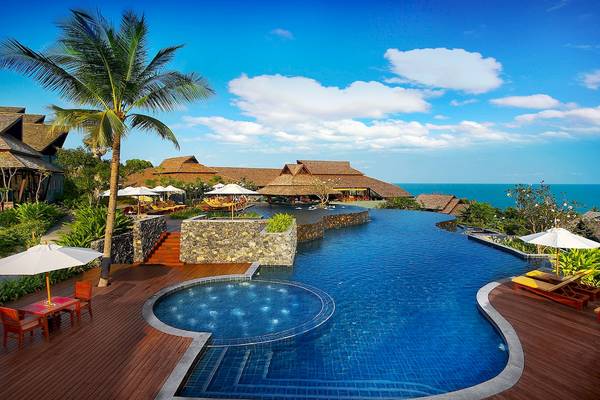 Außenpool des Nora Buri Resort & Spa mit Blick auf das Meer und umliegenden Gebäuden