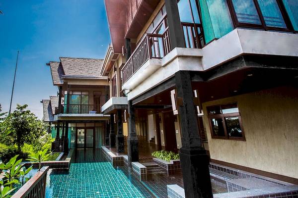 Außenansicht des Nora Buri Resort & Spa mit Swimmingpool und moderner Architektur.