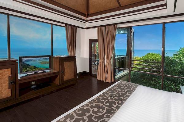 Suite im Nora Buri Resort & Spa mit Meerblick, große Fenster, Balkon, Fernseher und moderne Einrichtung.