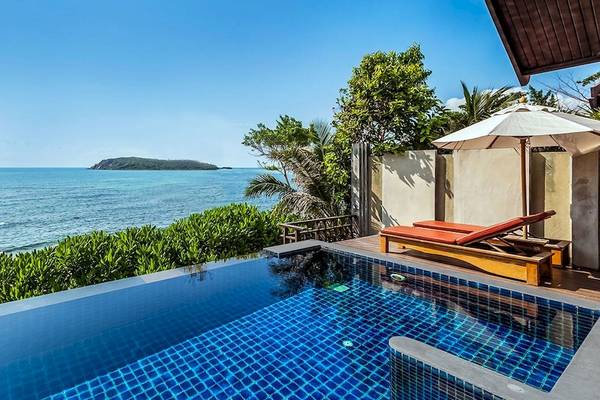 Pool mit Lounge-Liegen und Blick auf das Meer im Nora Buri Resort & Spa.
