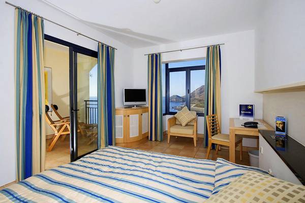 Playitas Hotel Zimmer mit Balkon und Meerblick, inklusive Fernseher, Schreibtisch und Stühle.