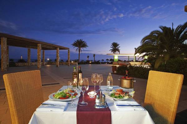 Abendessen im Freien im Playitas Hotel bei Nacht mit Blick auf Palmen und den Ozean.