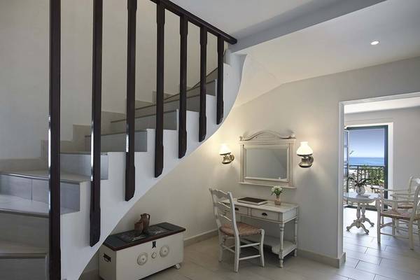 Innenraum des Creta Maris Resorts mit einer Treppe und einem Schreibtisch am Fenster.