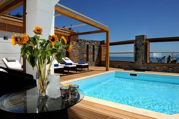 Pool mit Sonnenblumen und Loungebereich im Creta Maris Resort.