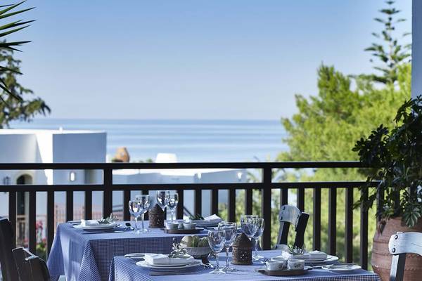 Blick vom Balkon des Creta Maris Resorts auf zwei gedeckte Tische mit Blick auf das Meer.