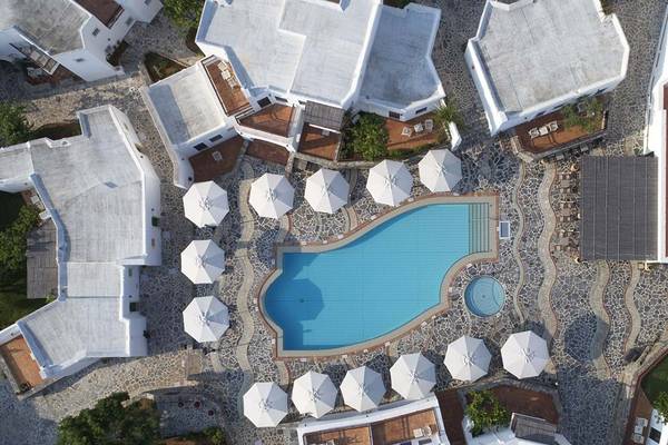 Luftaufnahme des Creta Maris Resorts mit Pool, weißen Sonnenschirmen und Gebäuden.