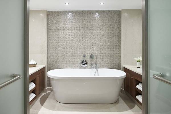 Ein Badezimmer mit einer freistehenden Badewanne und einer Mosaikwand.