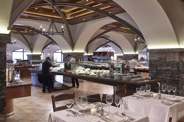 Innenansicht des Restaurants im Creta Maris Resort mit Speisenbuffet und besetzten Tischen.
