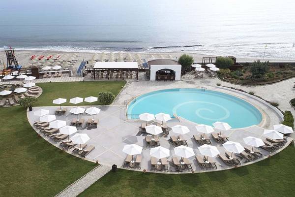Luftaufnahme des Creta Maris Resorts mit Pool, Liegen und Sonnenschirmen am Strand
