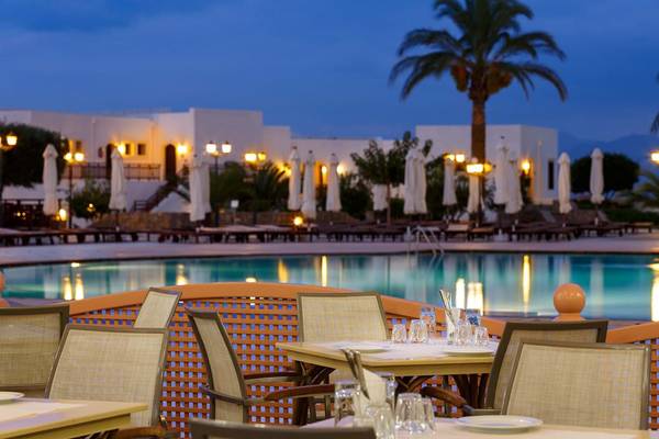 Abendessen am Pool im Creta Maris Resort mit Blick auf das Wasser und die Gebäude.