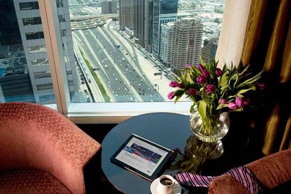 Aussicht aus dem Zimmer des Rose Rayhaan by Rotana Hotels auf eine Stadtstraße mit vielen Autos.