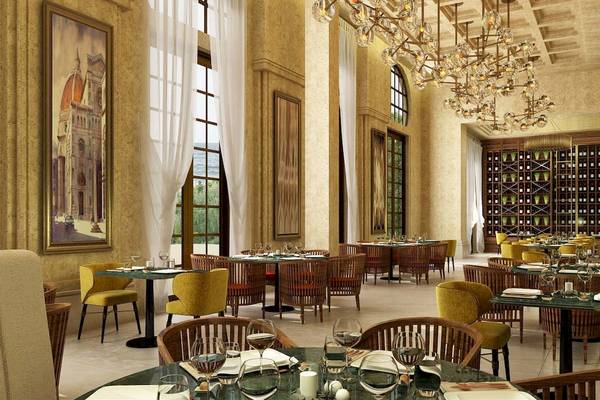 Innenansicht des Restaurants im Rixos Premium Saadiyat Island Hotel mit runden Tischen, Stühlen und Weinregalen.