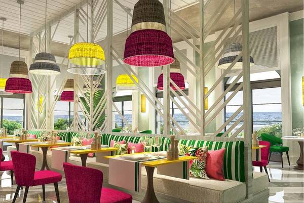 Innenraum des Restaurants des Rixos Premium Saadiyat Island Hotels mit bunten Lampen, Tischen und Stühlen.