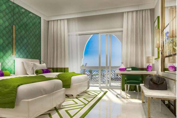 Zwei Betten mit grünen und weißen Laken im Rixos Premium Saadiyat Island Hotel Schlafzimmer.