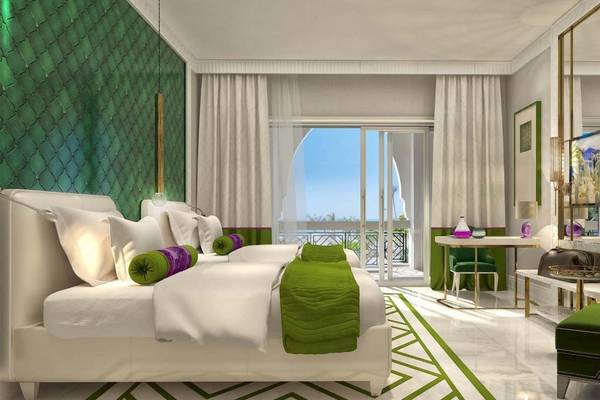 Doppelbettzimmer im Rixos Premium Saadiyat Island Hotel mit grünen und weißen Akzenten.