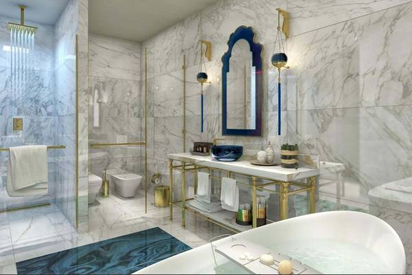 Luxusbadezimmer im Rixos Premium Saadiyat Island mit Marmorwänden, goldenen Armaturen und einer Badewanne.