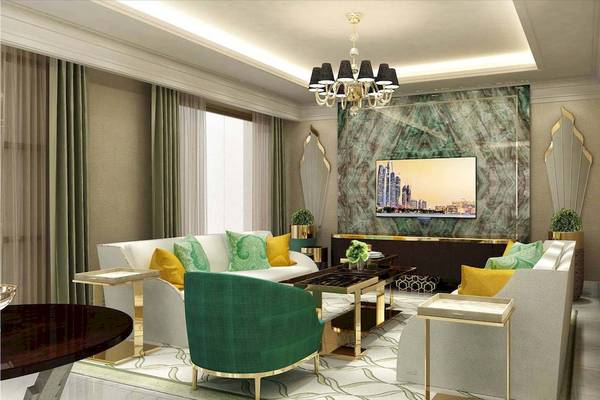 Luxuriöses Wohnzimmer im Rixos Premium Saadiyat Island Hotel mit grünen und gelben Kissen, einem Fernseher an der Wand und einer goldenen Deckenleuchte.