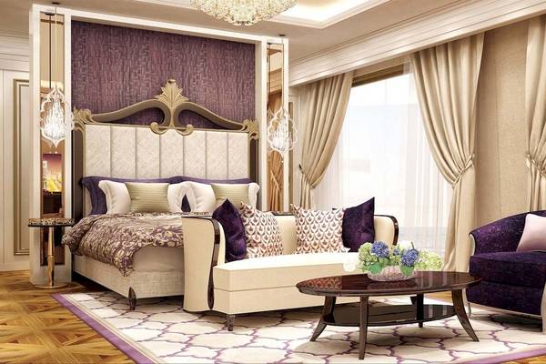 Luxuriöses Schlafzimmer im Rixos Premium Saadiyat Island Hotel mit einem großen Bett, Sofa, Tisch und Blumen.