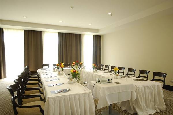 Konferenzraum im Sealife Buket Resort & Spa mit langen Tischen, Stühlen, Blumen und Projektor.