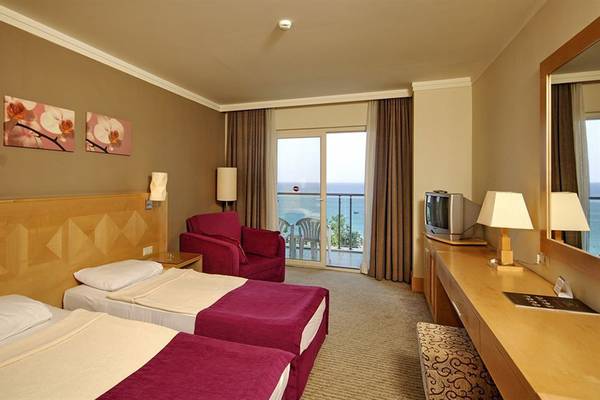 Doppelzimmer mit Meerblick im Sealife Buket Resort & Spa, mit zwei Betten, rotem Sessel und Balkon.