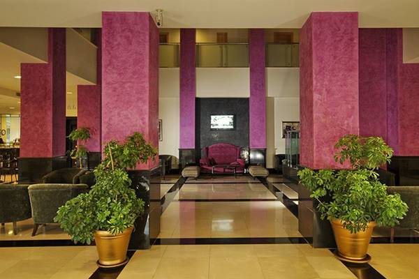 Lobby des Sealife Buket Resort & Spa mit hohen pinken Säulen und grünen Pflanzen in goldenen Töpfen.