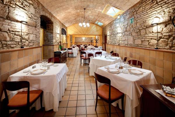 Innenansicht des Gargallo Rialto Restaurants mit steinernen Wänden und Tischdecken.