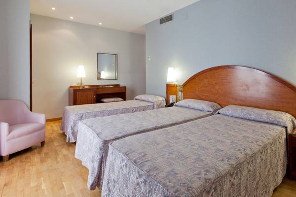 Doppelzimmer im Gargallo Rialto Hotel mit zwei Betten, Nachttischen und einem rosa Stuhl.