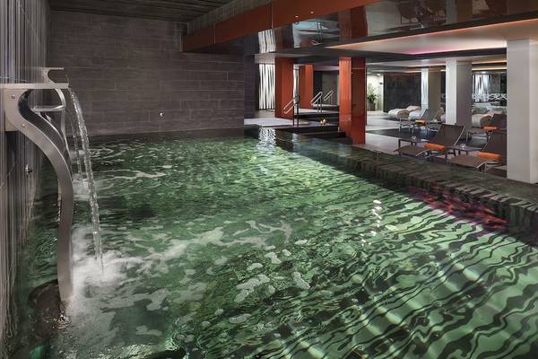 Innenpool im HD Beach Resort mit Wasserfall und Lounge-Bereich.