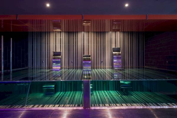 Sauna-Bereich im HD Beach Resort mit farbigen Lichtern und Glaswänden.