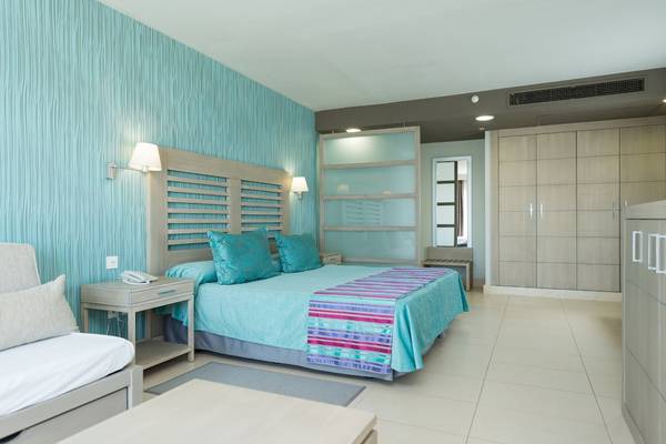 Schlafzimmer im HD Beach Resort mit blauen Wänden, einem großen Bett und modernen Möbeln.