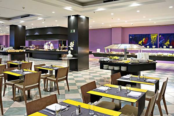 Innenansicht des Restaurants im Gran Canaria Princess Hotel mit geometrischem Boden, gepolsterten Stühlen und Tischen sowie Buffets.