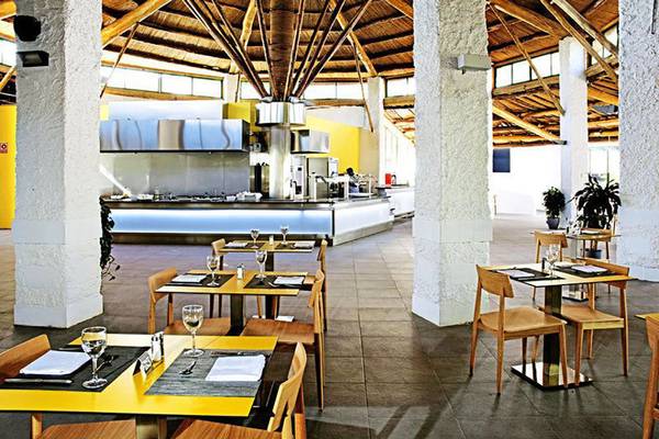 Innenansicht des Restaurants im Gran Canaria Princess Hotel mit gelben Tischen und Holzstühlen.