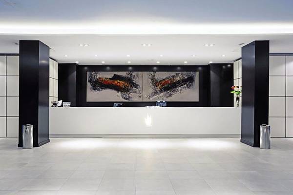 Empfangsbereich des Gran Canaria Princess Hotels mit modernem Design und großem Kunstwerk an der Wand.