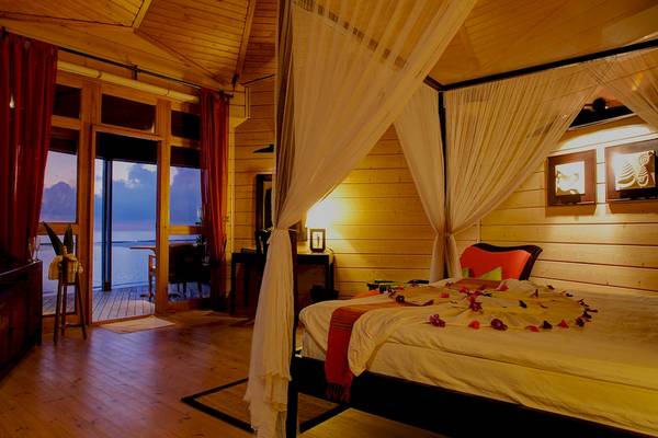 Schlafzimmer im Komandoo Island Resort & Spa mit Blick auf das Meer.