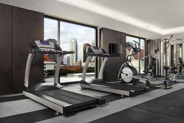 Fitnessbereich im Mövenpick Hotel Sukhumvit 15 Bangkok mit Laufbändern und anderen Geräten.