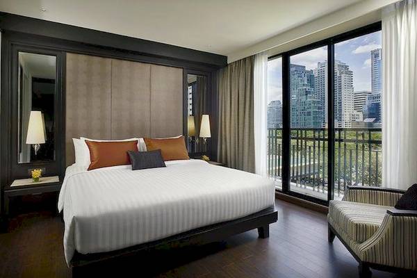 Ein Schlafzimmer im Mövenpick Hotel Sukhumvit 15 Bangkok mit einem großen Bett und einem Balkon.
