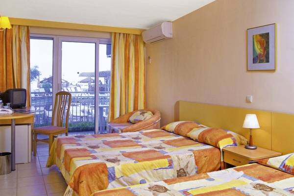 Doppelzimmer im Kaliopa Hotel mit zwei Betten, Schreibtisch, Fernseher und Balkon.