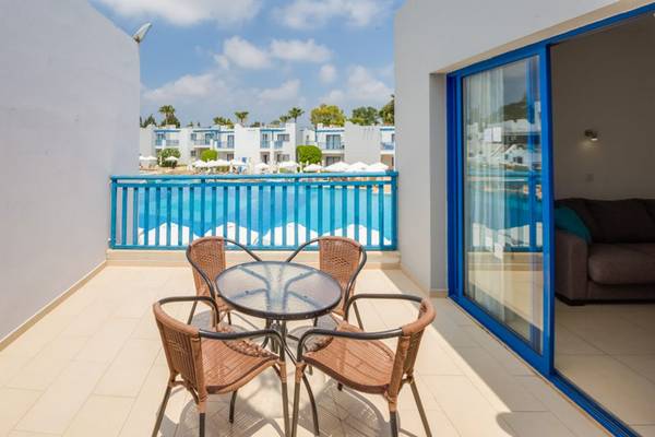 Balkon im Callisto Holiday Village mit Tisch und Stühlen, Blick auf den Pool.