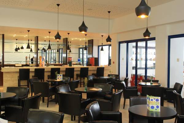 Innenbereich des Callisto Holiday Village Hotels mit modernen Möbeln und Loungebereichen.