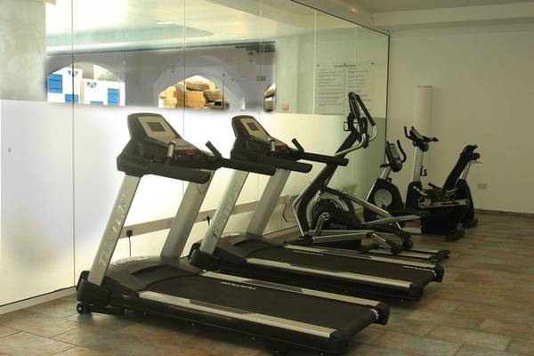 Fitnessraum im Callisto Holiday Village mit mehreren Laufbändern und anderen Geräten.